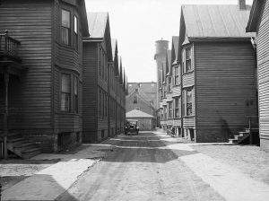 This April 1936 photograph shows the unpaved alley at 730 West Winnebago Street. 