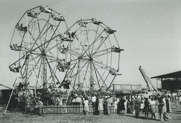1941 photograph of crowds lined up around the twin Ferris Wheels at Milwaukee's Midsummer Festival. 