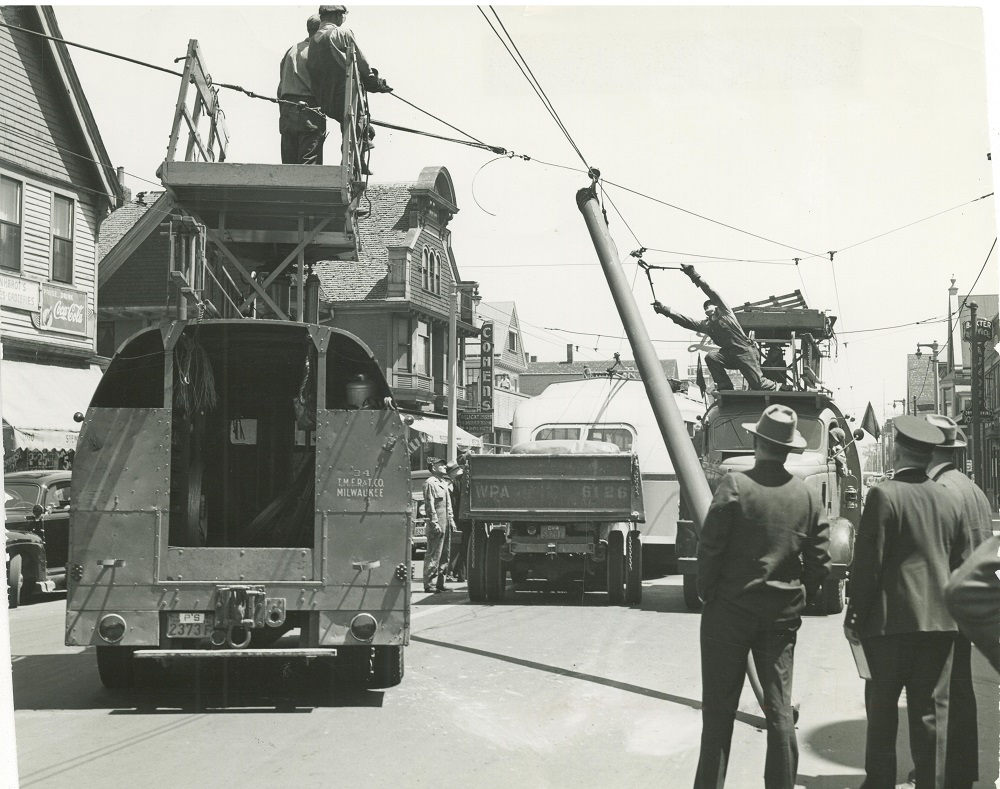 A team of men, some from the Milwaukee Electric Railway & Light Company and some employed by the Works Progress Administration, work to repair power lines on North Avenue. 