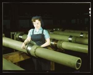 During World War II, the Chain Belt Company manufactured howitzers. Taken in 1943, this photo shows a female employee inspecting a howitzer component for metal burrs.
