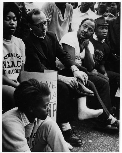 Father James Groppi rests with fellow marchers amid their demonstrations for fair housing in 1967.