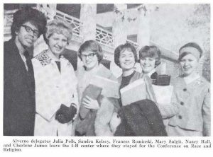 Alverno college students Julia Polk, Sandra Kelsey, Frances Rominski, Mary Sulgit, Nancy Hall, and Charlene James, smiling in their Fall outfits. Some wear glasses and coats, some hold books, as they pose in front of a building.