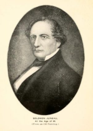 A painted portrait of Solomon Juneau facing left in formal attire. Beneath the drawing reads "Solomon Juneau at the Age of 60 (from an oil painting)."