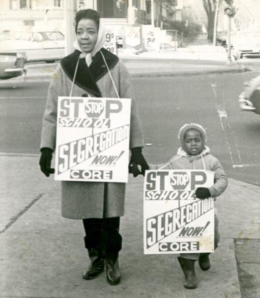 A woman and small child carry signs calling for the end of Milwaukee school segregation in 1964. 