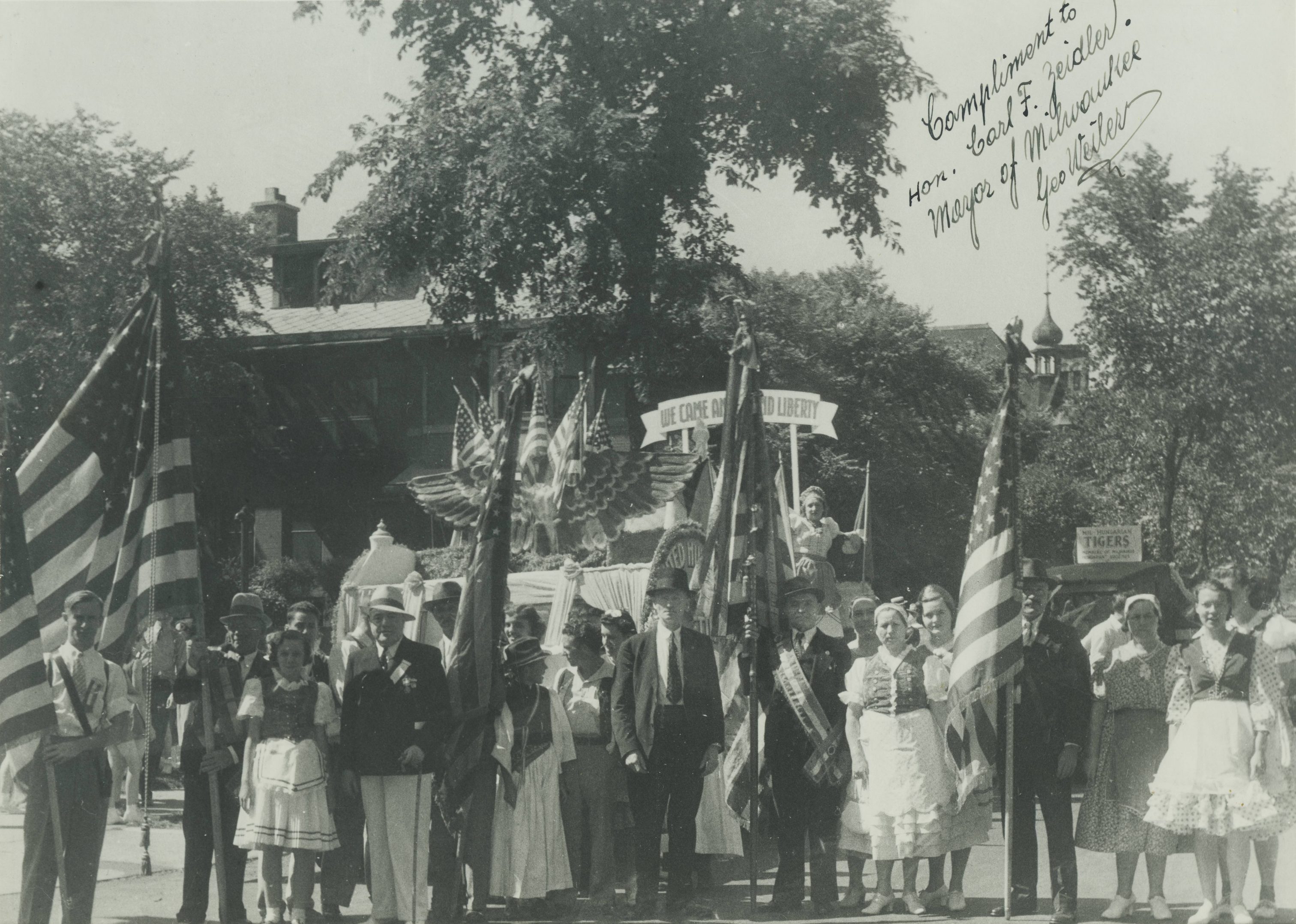 A group of people from the U.S. American Hungarian Societies of Wisconsin stand in front of their float at the 1940 Midsummer Festival.