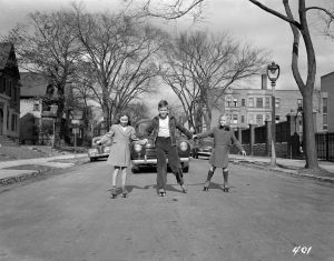 Three children roller skate down a Milwaukee street in this photograph from October 1943. 