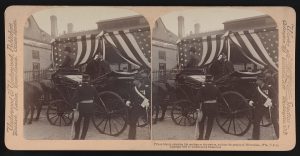 Two identical grayscale portraits of Prince Henry tipping his hat in a horse-drawn carriage. His face and front body are visible. The coachman and the horse face to the left. Several people in uniforms appear near the carriage wheels on the right. An American flag-patterned curtain is attached to the building behind the Prince. The photos are set side by side, flanked with texts. The text beneath the portrait on the right reads, "Prince Henry entering his carriage at the station, salutes the people of Milwaukee, Wis., U.S.A. Copyright 1902 by Underwood & Underwood."