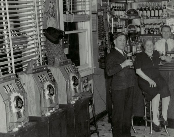 In this photograph from 1942, three slot machines line the wall of the Star Bar and Grill Room in Kenosha County.