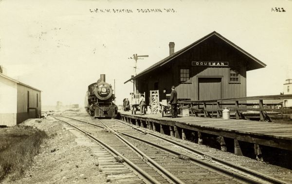 The Chicago and North Western Railway first built a station in Dousman in the 1880s. It is pictured here in 1910 with several individuals standing on the platform. 