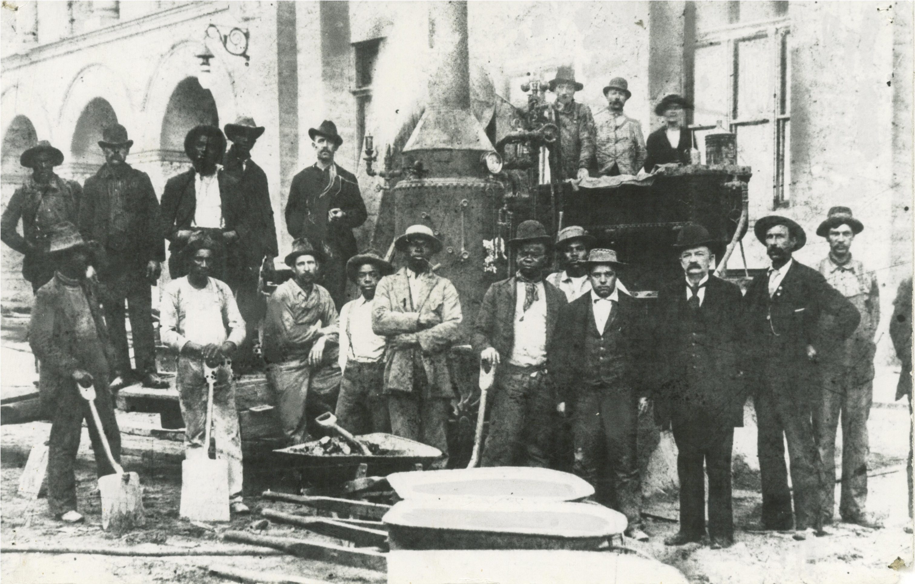 A group of African American construction workers, along with some Caucasian men, pose for a photograph as they work on Milwaukee's City Hall in 1896. 