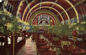A painted postcard of the Schlitz Palm Garden's interior in predominantly red and green color. It shows an array of dining tables and palm trees scattered in the hall under its vaulted ceiling. Inscribed in red ink on the bottom part of the painting is "Interior Schlitz Palm Garden, Milwaukee."