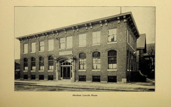 A grayscale image of the facade of the Abraham Lincoln House. The two-story brick building features an entrance and arched windows on the ground level, and rectangular windows on the upper level. Text beneath the image reads "Abraham Lincoln House."