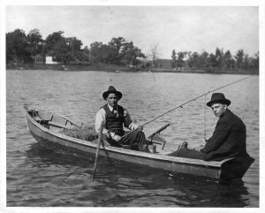 Two Milwaukee men fish from their small rowboat in this twentieth century photograph. 