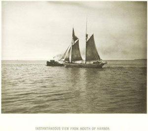Sepia-colored long shot of a tugboat pulling a sailing ship in Lake Michigan to the left. Text beneath the image reads "Instantaneous View From Mouth of Harbor."