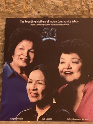A portrait of the founding mothers of the Indian Community School hangs over a fireplace. The photograph celebrates the fiftieth anniversary of the school's founding.